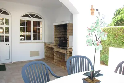 a patio with two chairs and a table with a fireplace at 6 Bedroom Private Villa Tenazinha I, with private pool in Albufeira