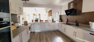 a large kitchen with white cabinets and a large window at 6 Bedroom Private Villa Tenazinha I, with private pool in Albufeira