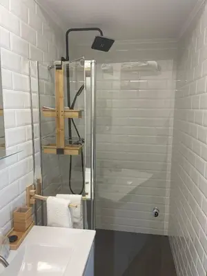 a bathroom with a glass shower and a sink at Quinta Verde Albufeira in Albufeira