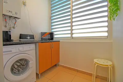 a laundry room with a washing machine and a window at AlbufeiraMar Beach Apartment in Albufeira