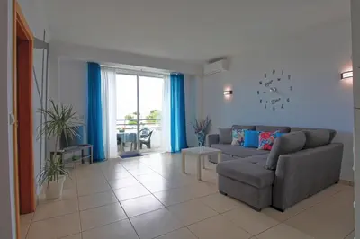 a living room with a couch and a window at AlbufeiraMar Beach Apartment in Albufeira