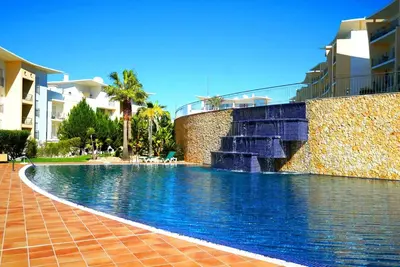 a swimming pool with a water fountain next to a building at AlbufeiraOrada Gloaming by Be Cherish in Albufeira