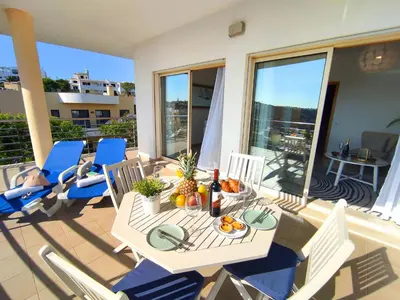 a table and chairs on a balcony with food on it at AlbufeiraOrada Gloaming by Be Cherish in Albufeira
