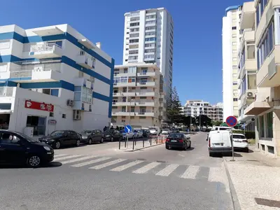 a street with cars parked in a city with tall buildings at T1 Torre 17 Vista Cidade in Quarteira