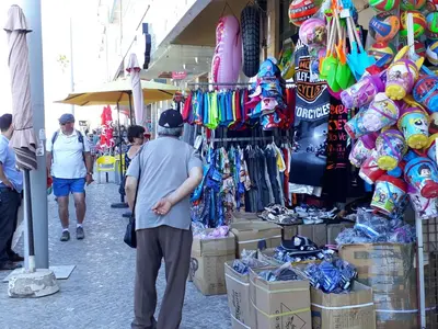 a man standing in front of a store in a market at T1 Torre 17 Vista Cidade in Quarteira
