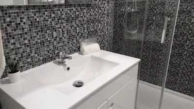 a bathroom with a white sink and a shower at T1 Torre 17 Vista Cidade in Quarteira