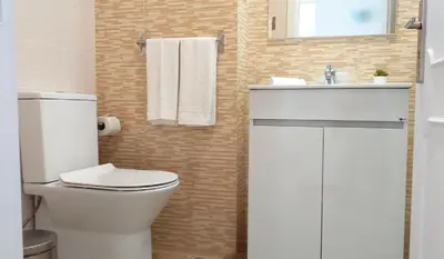 a bathroom with a white toilet and a sink at T1 Mira Praia 7 - Remodelado, Ar-Condicionado, Vista Mar, Wifi in Quarteira