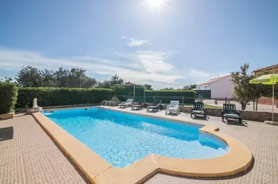 a swimming pool with chairs and an umbrella at Casa Santa Maria in Boliqueime