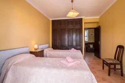 a bedroom with two beds with pink towels on them at Casa Santa Maria in Boliqueime