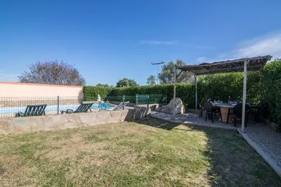 a patio with a table and chairs next to a pool at Casa Santa Maria in Boliqueime