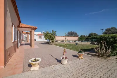a brick walkway with three potted plants next to a house at Casa Santa Maria in Boliqueime