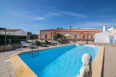 a swimming pool with a dog statue next to a house at Casa Santa Maria in Boliqueime