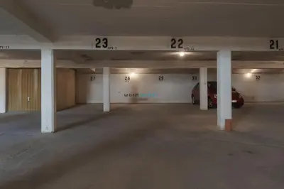 an empty parking garage with a car parked in it at Regueiró Quarteira Beach Apartment in Quarteira