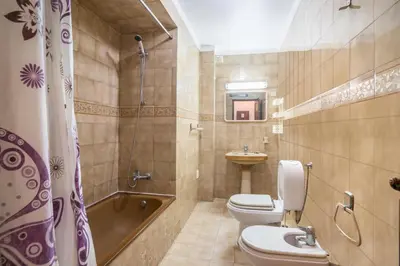 a bathroom with a tub and a toilet and a sink at Regueiró Quarteira Beach Apartment in Quarteira