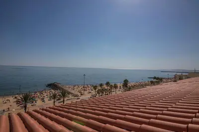 a view of a beach with people and the ocean at Regueiró Quarteira Beach Apartment in Quarteira
