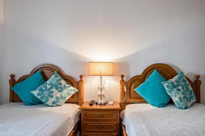a bedroom with two beds with blue pillows at Regueiró Quarteira Beach Apartment in Quarteira
