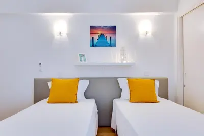 two beds with yellow pillows in a room at AL - Apartamento 1021 Impervilla in Quarteira