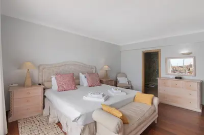 a bedroom with a bed and a table with a desk at Marina Vilamoura Penthouse Luxury in Vilamoura