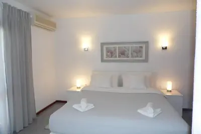 a white bedroom with two white beds and two lights at Happy House-fantastic holiday with all amenities in Albufeira