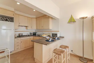 a kitchen with a counter and two chairs in it at Sail Away in Quarteira