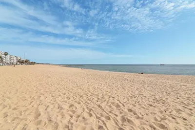 a sandy beach with a view of the ocean at Sail Away in Quarteira