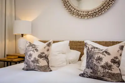 a bedroom with a bed with white pillows and a mirror at M&M Home in Quinta do Lago