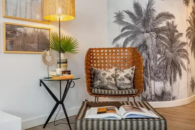 a room with a chair with a book on a table at M&M Home in Quinta do Lago