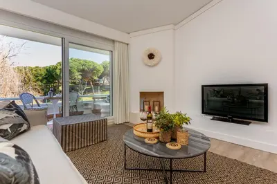a living room with a couch and a tv at M&M Home in Quinta do Lago