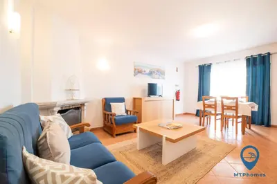 a living room with a blue couch and a table at Vila Nico by MTPhomes in Albufeira