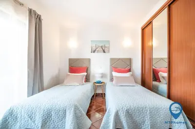 a bedroom with two beds and a mirror at Vila Nico by MTPhomes in Albufeira