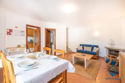 a dining room with a table and a living room at Vila Nico by MTPhomes in Albufeira