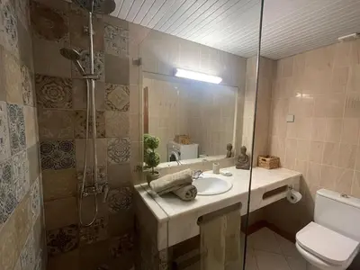 a bathroom with a sink and a shower and a toilet at Apartamento Varandas do Mar in Albufeira