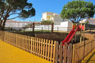 a playground with a red slide in a park at Heated Pool 6 Bedroom Private Villa in Center of Olhos de Água in Albufeira