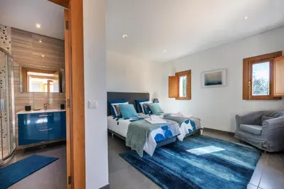 a bedroom with two beds and a bathroom at Sunny House in Loulé