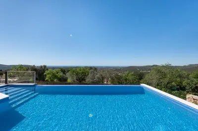 a swimming pool with a sunset in the background at Sunny House in Loulé