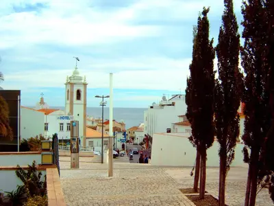 a kitchen with red cabinets and a table and chairs at Bay View Old Town Apartments in Albufeira