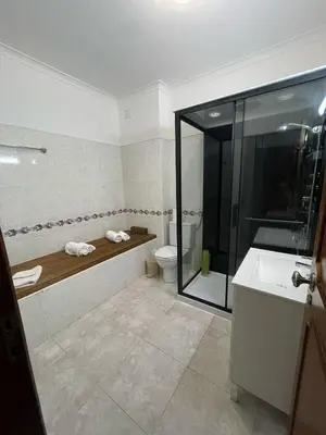a bathroom with a shower and a toilet and a sink at cantinho do mar in Albufeira