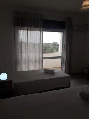 a bedroom with a bed and a large window at cantinho do mar in Albufeira