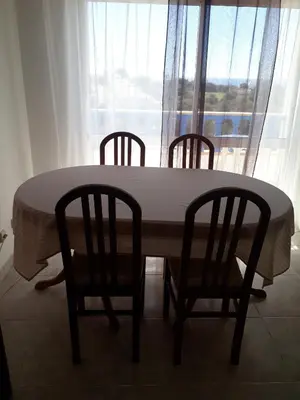 a table and chairs with a table and a window at cantinho do mar in Albufeira