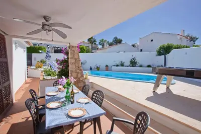 a patio with a table and a piano next to a pool at Villa Dela by Villa Plus in Albufeira