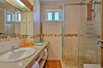 a bathroom with a sink and a glass shower at Villa Dela by Villa Plus in Albufeira