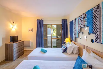 a bedroom with two beds and a television at Carolina Sea Apartment in Albufeira