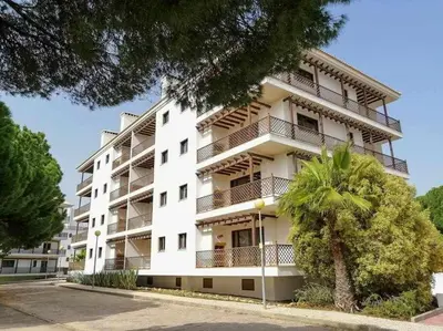 a white building with a palm tree in front of it at Falésia Park - Dream Lodging in Albufeira
