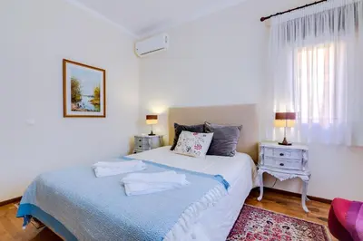 a white bedroom with a bed and a window at LovelyStay - Villa Mimi in Vilamoura