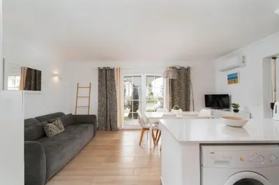 a kitchen and living room with a couch and a table at Sweet Old Village in Quarteira