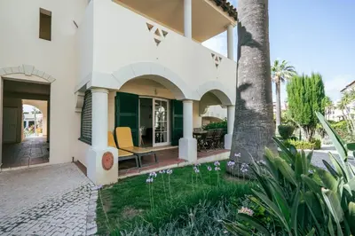 a house with a courtyard with a palm tree at Sweet Old Village in Quarteira