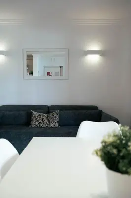 a living room with a blue couch and a mirror at Sweet Old Village in Quarteira