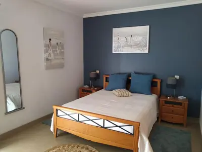a bedroom with a bed with blue walls and a mirror at J&J Home T2 next to Pinhal Velho, Terraces of Pinhal, Vilamoura in Quarteira