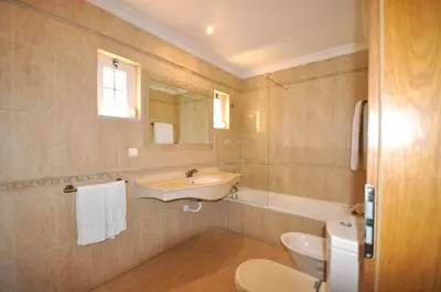 a bathroom with a sink and a tub and a toilet at A stylish villa with a private pool, short drive from the centre, free AC Wifi in Quarteira