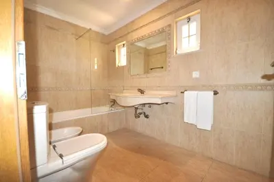 a bathroom with a sink and a toilet and a tub at A stylish villa with a private pool, short drive from the centre, free AC Wifi in Quarteira